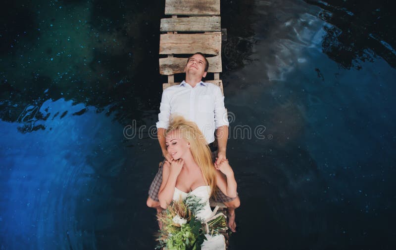 Portret van een sensueel jong paar die op een houten brug koesteren royalty-vrije stock fotografie Portret van een sensueel jong paar die op een houten brug koesteren royalty-vrije stock fotografie