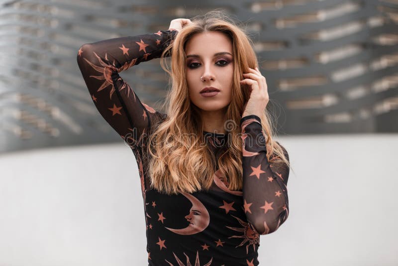 Portret van een sexy jonge vrouw met rood haar met een mooie samenstelling met een oorring in neus in een in zwarte blouse stock foto Portret van een sexy jonge vrouw met rood haar met een mooie samenstelling met een oorring in neus in een in zwarte blouse stock foto