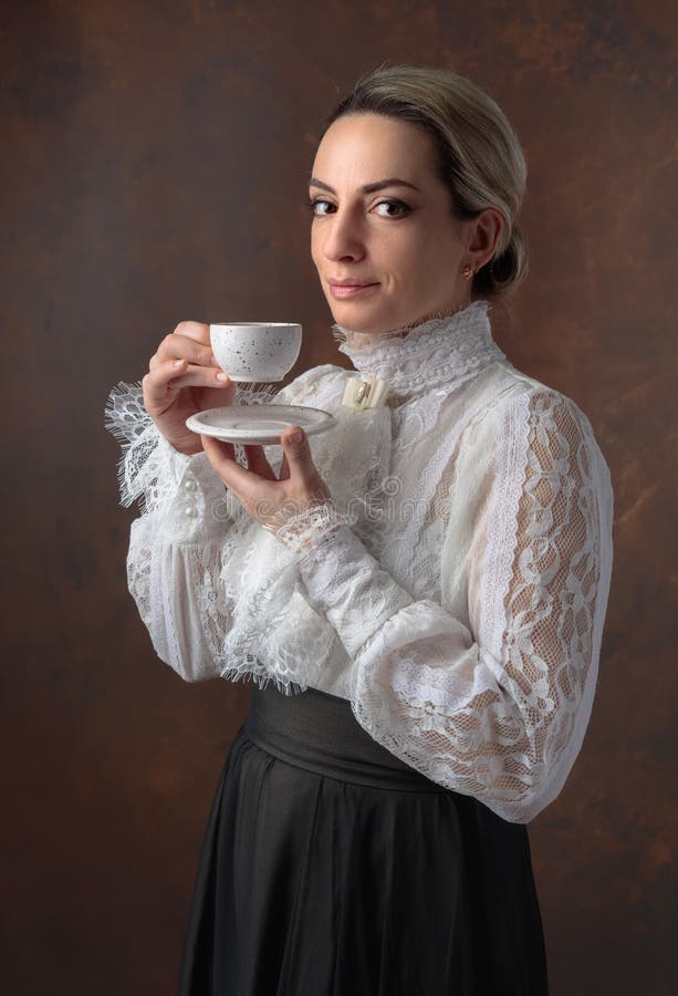 Portret van een vrouw in Victoriaanse kleren met een kop van koffie royalty-vrije stock foto Portret van een vrouw in Victoriaanse kleren met een kop van koffie royalty-vrije stock foto