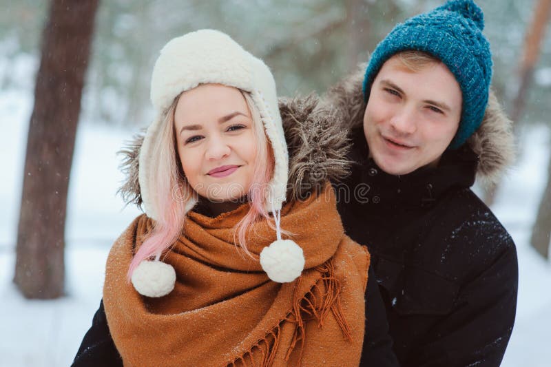 Portret van gelukkig jong paar die in de winter sneeuwbos lopen royalty-vrije stock afbeeldingen Portret van gelukkig jong paar die in de winter sneeuwbos lopen royalty-vrije stock afbeeldingen