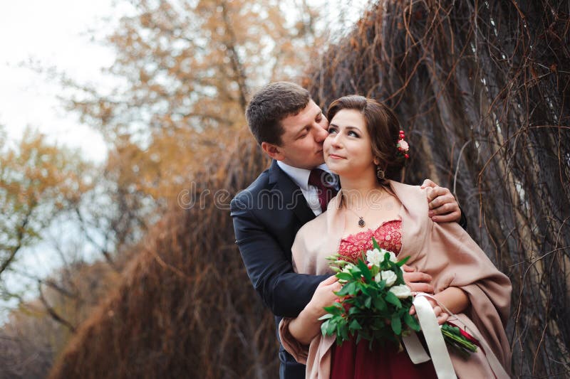 Portret van gelukkige jonggehuwden in de herfstaard Gelukkige bruid en gr. stock foto Portret van gelukkige jonggehuwden in de herfstaard Gelukkige bruid en gr. stock foto