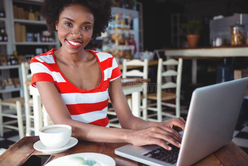 Portret van glimlachende vrouw die aan laptop werken royalty-vrije stock afbeelding Portret van glimlachende vrouw die aan laptop werken royalty-vrije stock afbeelding