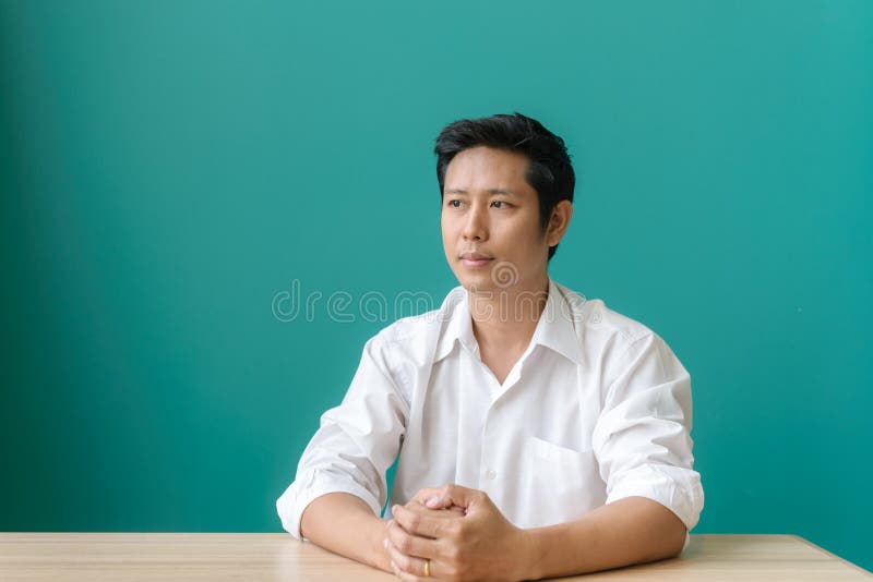 Portret van het Aziatische zakenman glimlachen en het bekijken camera met glimlach terwijl het zitten op zijn werkende plaats van stock fotografie Portret van het Aziatische zakenman glimlachen en het bekijken camera met glimlach terwijl het zitten op zijn werkende plaats van stock fotografie