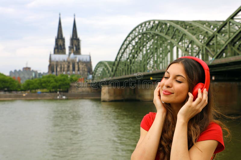 Portret van het jonge ontspannen vrouw luisteren aan muziek met stedelijke achtergrond Stadsmeisje die met rode hoofdtelefoon van royalty-vrije stock foto Portret van het jonge ontspannen vrouw luisteren aan muziek met stedelijke achtergrond Stadsmeisje die met rode hoofdtelefoon van royalty-vrije stock foto