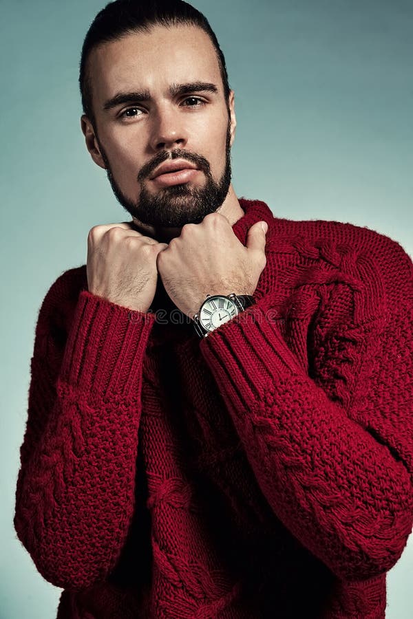 Portret van het knappe lumbersexual model van manier modieuze hipster gekleed in het warme rode sweater stellen in studio royalty-vrije stock afbeeldingen Portret van het knappe lumbersexual model van manier modieuze hipster gekleed in het warme rode sweater stellen in studio royalty-vrije stock afbeeldingen