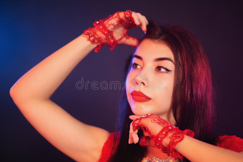 Portret van het mooie traditionele oosterse het meisje van de buikdanser dansen op blauwe neon rokerige achtergrond Vrouw in rode stock afbeelding Portret van het mooie traditionele oosterse het meisje van de buikdanser dansen op blauwe neon rokerige achtergrond Vrouw in rode stock afbeelding