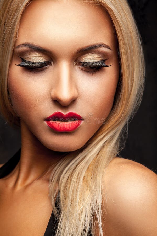 Portret van het wijfje die van het schoonheidsblonde neer in studio met pro kijken stock foto Portret van het wijfje die van het schoonheidsblonde neer in studio met pro kijken stock foto