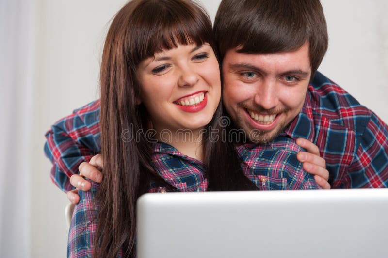 Portret van jong lachend paar die laptop thuis met behulp van royalty-vrije stock foto's Portret van jong lachend paar die laptop thuis met behulp van royalty-vrije stock foto's