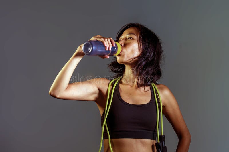 Portret van jonge atletische en geschikte Aziatische Koreaanse vrouw in de flessen drinkwater van de geschiktheids hoogste holdin stock afbeeldingen Portret van jonge atletische en geschikte Aziatische Koreaanse vrouw in de flessen drinkwater van de geschiktheids hoogste holdin stock afbeeldingen