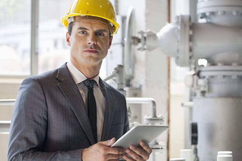 Portret van jonge mannelijke de tabletcomputer van de architectenholding in de industrie stock afbeeldingen Portret van jonge mannelijke de tabletcomputer van de architectenholding in de industrie stock afbeeldingen