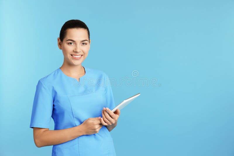 Portret van jonge medische medewerker met tablet op kleurenachtergrond