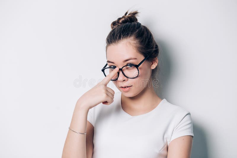 Portret van jonge mooie donkerbruine vrouw met glazen op witte achtergrond stock foto Portret van jonge mooie donkerbruine vrouw met glazen op witte achtergrond stock foto