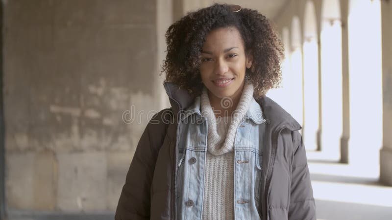 Portret van jonge mooie gemengde rasvrouw met afrokapsel het lopen