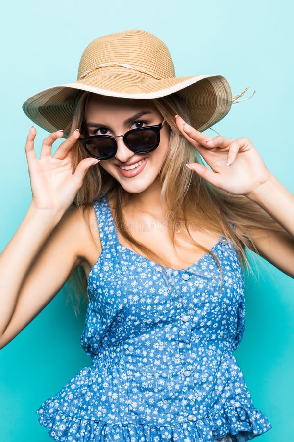 Portret van jonge mooie vrouw in de zomerhoed en zonnebril op blauwe achtergrond stock fotografie Portret van jonge mooie vrouw in de zomerhoed en zonnebril op blauwe achtergrond stock fotografie
