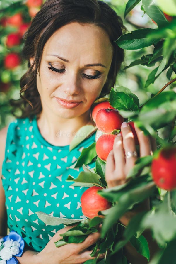 Portret van jonge vrouw met rode appel in tuin stock afbeelding Portret van jonge vrouw met rode appel in tuin stock afbeelding