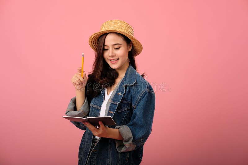 Portret van lachende aziatische vrouw met jasjas met laptop en potlood studio shot stock afbeelding Portret van lachende aziatische vrouw met jasjas met laptop en potlood studio shot stock afbeelding