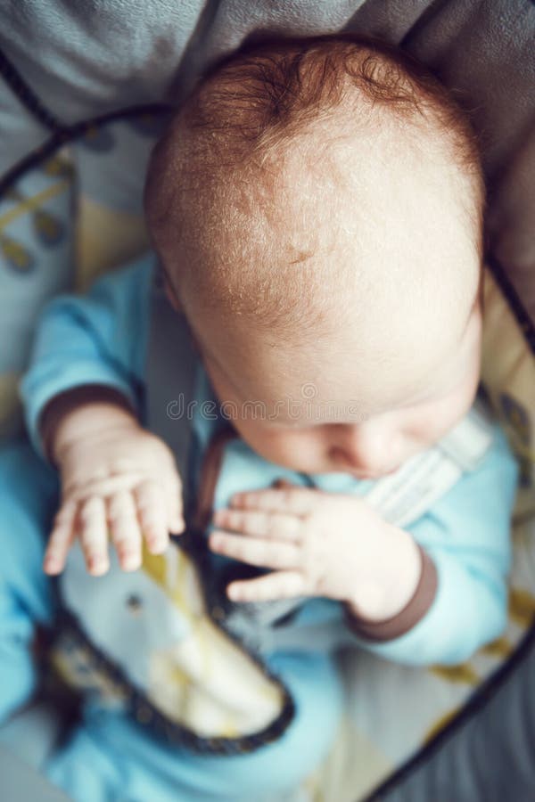 Portret van leuke aanbiddelijke witte Kaukasische slaap weinig babyjongen pasgeboren in blauwe kleren die als schommelingsvoorzit royalty-vrije stock afbeelding Portret van leuke aanbiddelijke witte Kaukasische slaap weinig babyjongen pasgeboren in blauwe kleren die als schommelingsvoorzit royalty-vrije stock afbeelding
