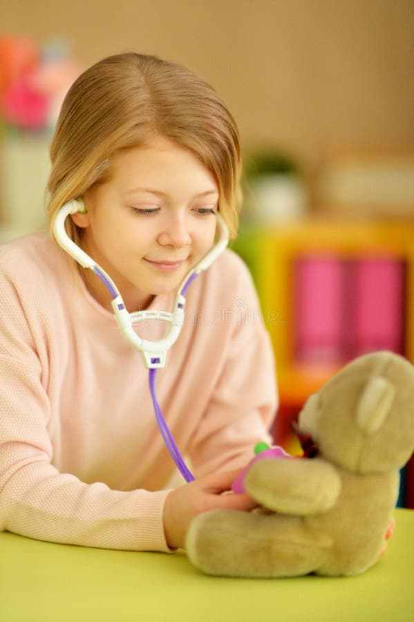 Portret van meisje speelverpleegster, inspecterende teddybeer met stethoscoop stock afbeeldingen Portret van meisje speelverpleegster, inspecterende teddybeer met stethoscoop stock afbeeldingen