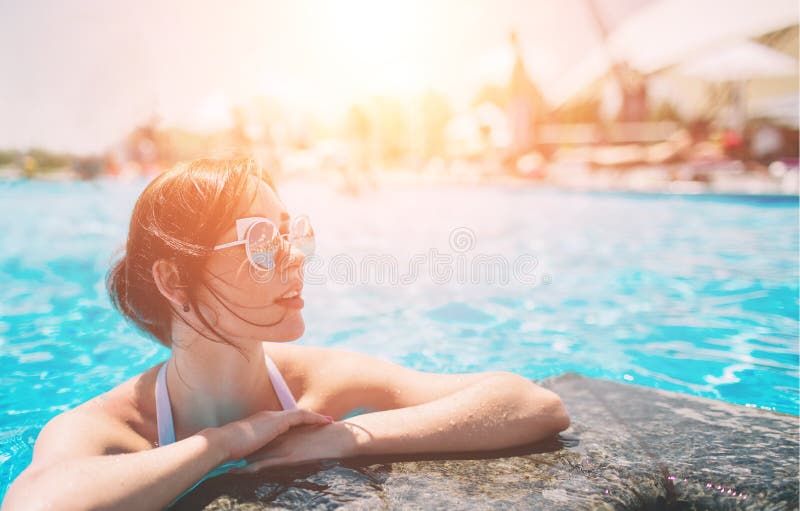 Portret van mooie gelooide vrouw in het witte swimwear ontspannen in zwembadkuuroord Hete de zomerdag en heldere zonnig royalty-vrije stock afbeeldingen Portret van mooie gelooide vrouw in het witte swimwear ontspannen in zwembadkuuroord Hete de zomerdag en heldere zonnig royalty-vrije stock afbeeldingen