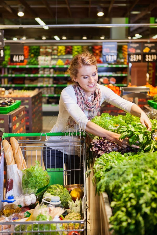 Portret van mooie jonge vrouw die groene bladgroente kiezen royalty-vrije stock afbeelding Portret van mooie jonge vrouw die groene bladgroente kiezen royalty-vrije stock afbeelding