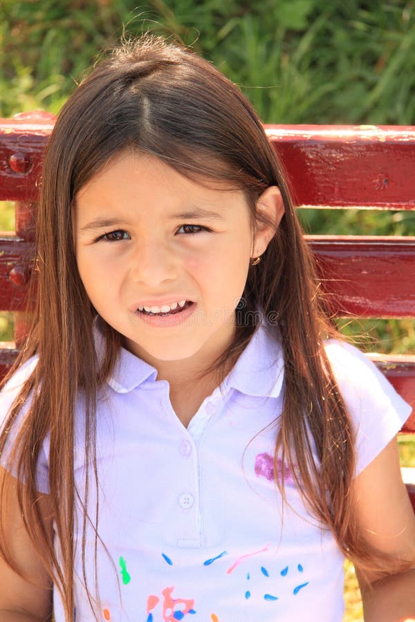 Face of an unhappy little girl with long hair in lila t-shirt. Face of an unhappy little girl with long hair in lila t-shirt