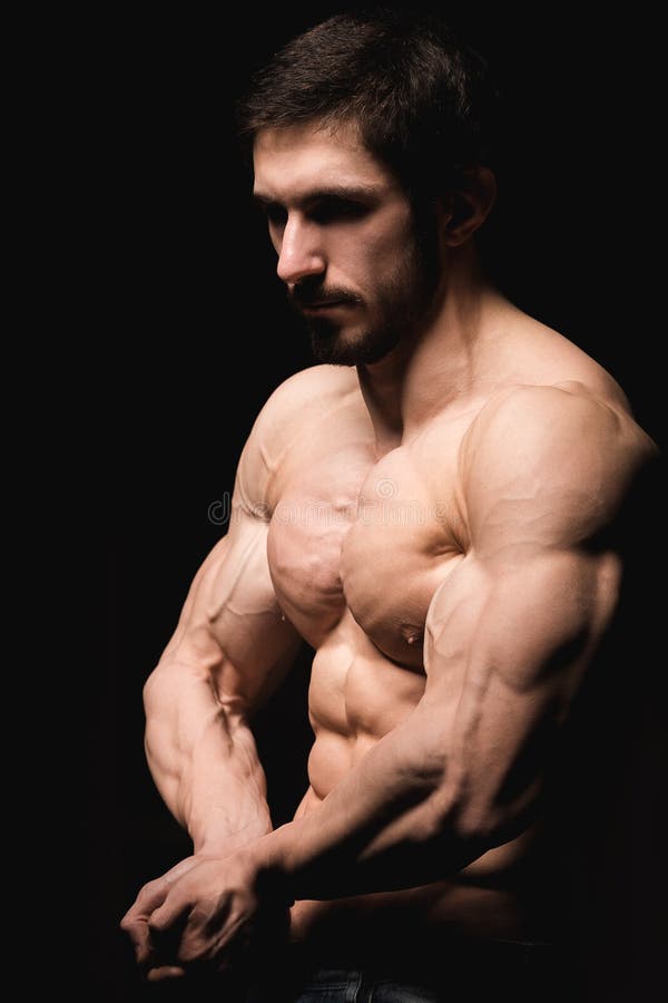Portret van shirtless spiermens in jeans Jonge mannelijke homp die zijn perfecte lichaam en spieren op zwarte achtergrond tonen stock afbeelding Portret van shirtless spiermens in jeans Jonge mannelijke homp die zijn perfecte lichaam en spieren op zwarte achtergrond tonen stock afbeelding