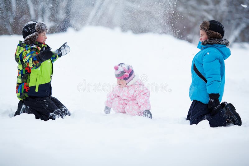 Portret van Twee vrolijke gelukkige jongens en babymeisje in de winterpark stock foto's Portret van Twee vrolijke gelukkige jongens en babymeisje in de winterpark stock foto's