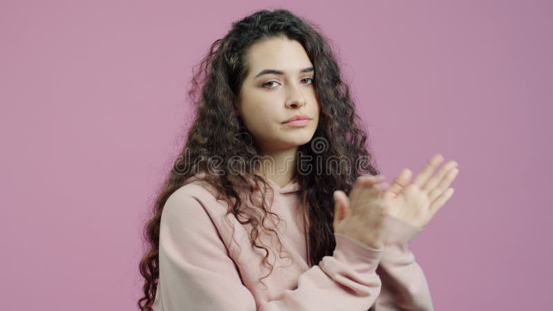 Portret van vermoeide en verveelde jonge vrouw die handen klapt met ongelukkige expressie