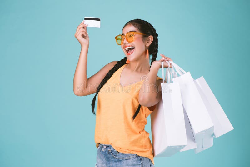 Portret van vrolijke jonge donkerbruine vrouwenholding creditcard en het winkelen zakken royalty-vrije stock foto Portret van vrolijke jonge donkerbruine vrouwenholding creditcard en het winkelen zakken royalty-vrije stock foto