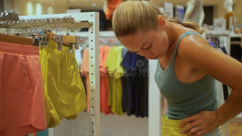 Portret van winkeliersvrouw in mode boutique. selecteert touchkleding op een zwarte friday aantrekkelijk meisje