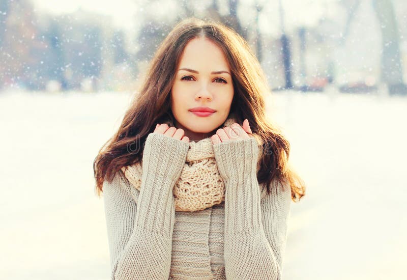 Portret vrij jonge vrouw die een gebreide sweater en een sjaal in de winter over sneeuwvlokken dragen stock afbeeldingen Portret vrij jonge vrouw die een gebreide sweater en een sjaal in de winter over sneeuwvlokken dragen stock afbeeldingen