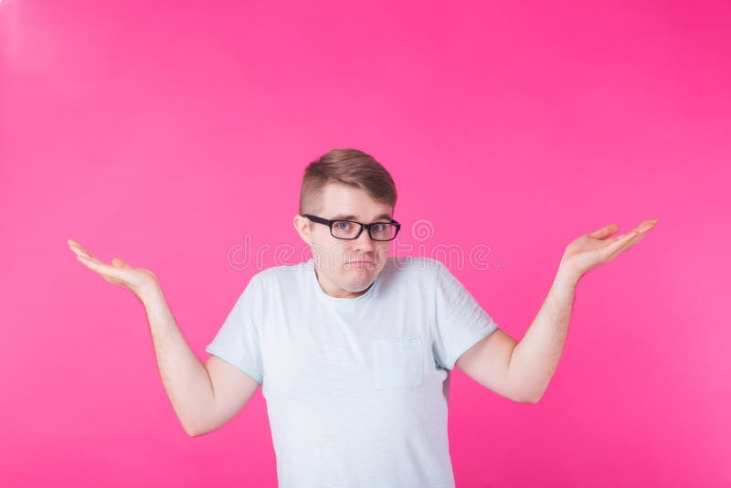 Portrait of confused man showing I don`t know gesture on pink background. Portrait of confused man showing I don`t know gesture on pink background.