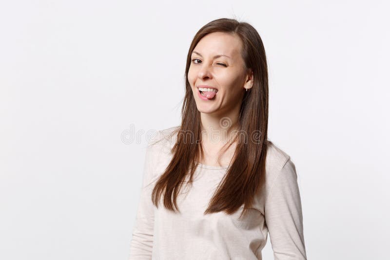 Portret śmiesznego rozochoconego mrugania ładna młoda kobieta w świetle odziewa pokazywać jęzor odizolowywającego na biel ściany zdjęcie royalty free Portret śmiesznego rozochoconego mrugania ładna młoda kobieta w świetle odziewa pokazywać jęzor odizolowywającego na biel ściany zdjęcie royalty free