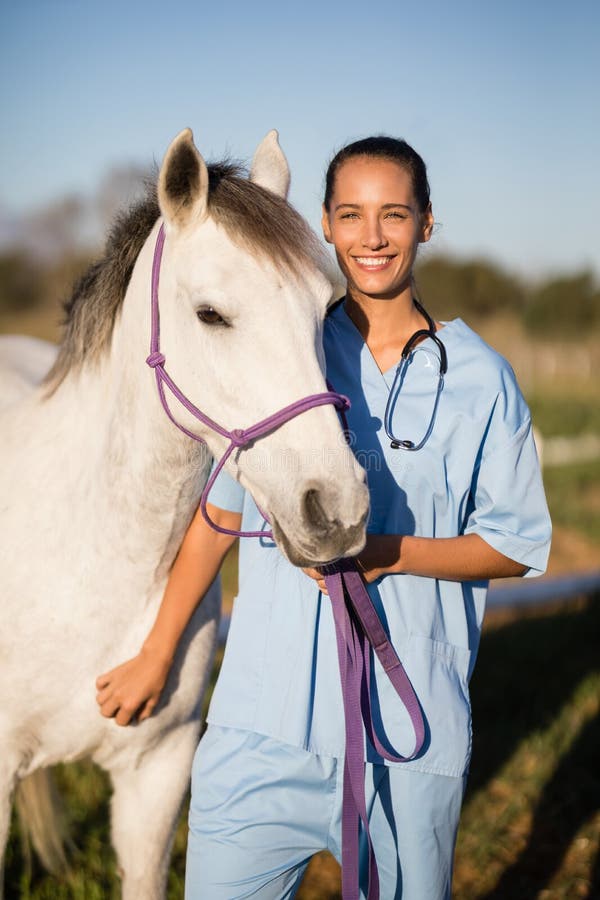 Portreta uśmiechnięty żeński weterynarz koniem