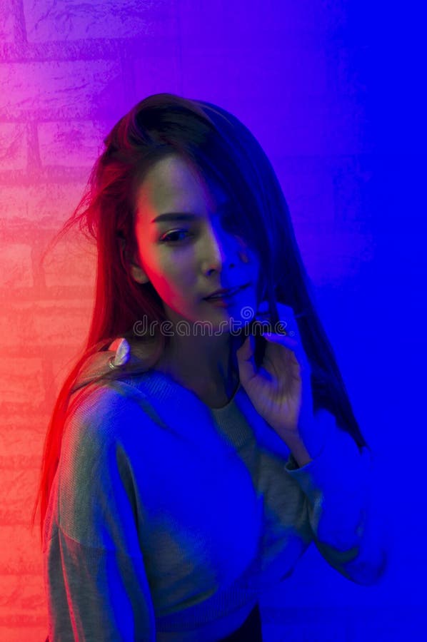 Portretmanier van een Aziatische vrouw in neon-viooltje en rood licht dat in dark met schoonheid en sexy glanst, verleidelijk, he stock foto Portretmanier van een Aziatische vrouw in neon-viooltje en rood licht dat in dark met schoonheid en sexy glanst, verleidelijk, he stock foto