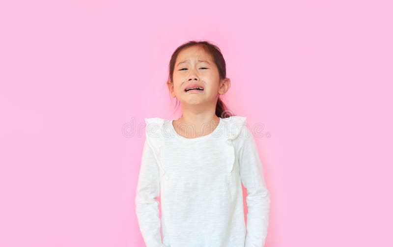 Portrait asian little child girl crying isolated on pink background. Kid with sad expressions. Portrait asian little child girl crying isolated on pink background. Kid with sad expressions.