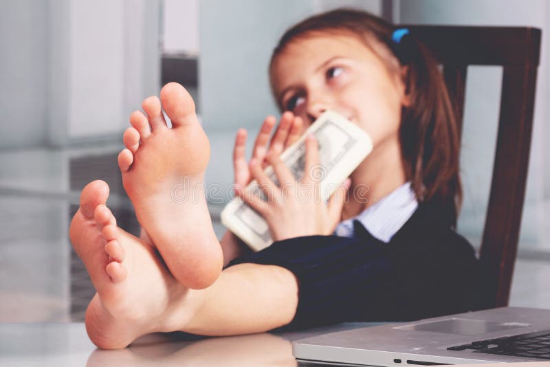 Portretul tinerei afaceri foarte fericite și drăguțe, cu picioarele goale pe masă, și numără banii profitând. concentrare selectiv stock photos