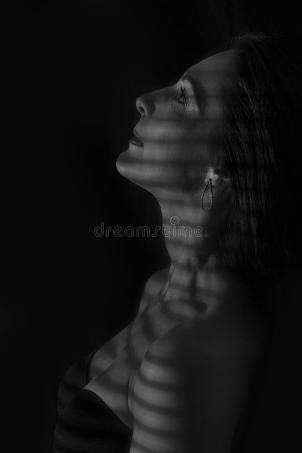 Portretul unei femei care se prezintă în întuneric cu linii întunecate de conversie artistică orbitoare stock photography