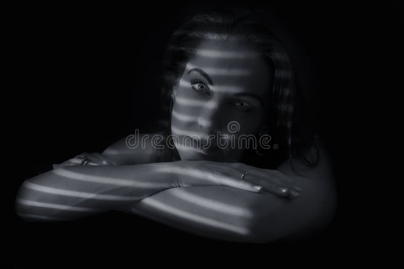 Portretul unei femei stând în întuneric cu linii întunecate de bl stock photos
