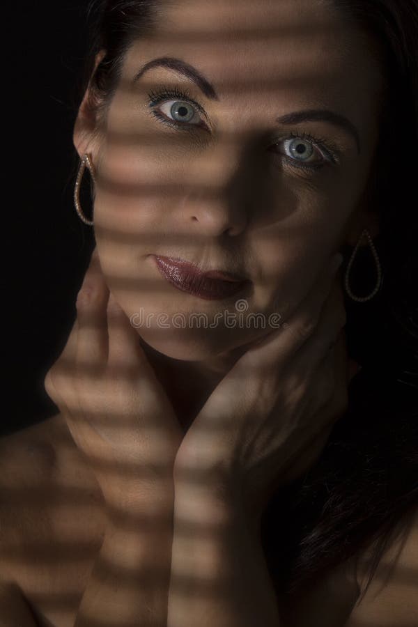 Portretul unei femei stând în întuneric cu linii întunecate de bl royalty free stock images