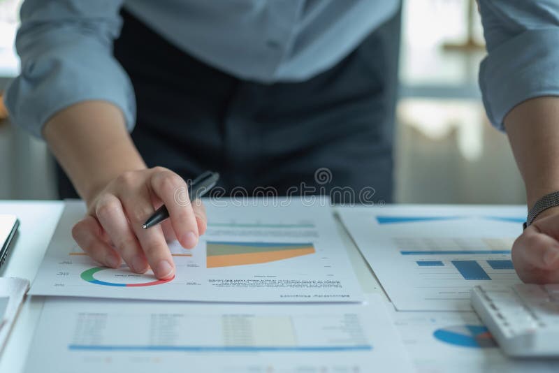 Portretul unui contabil feminin care utilizează un calculator și un laptop pentru a calcula echilibrul utilizând grafice pentru cl royalty free stock images