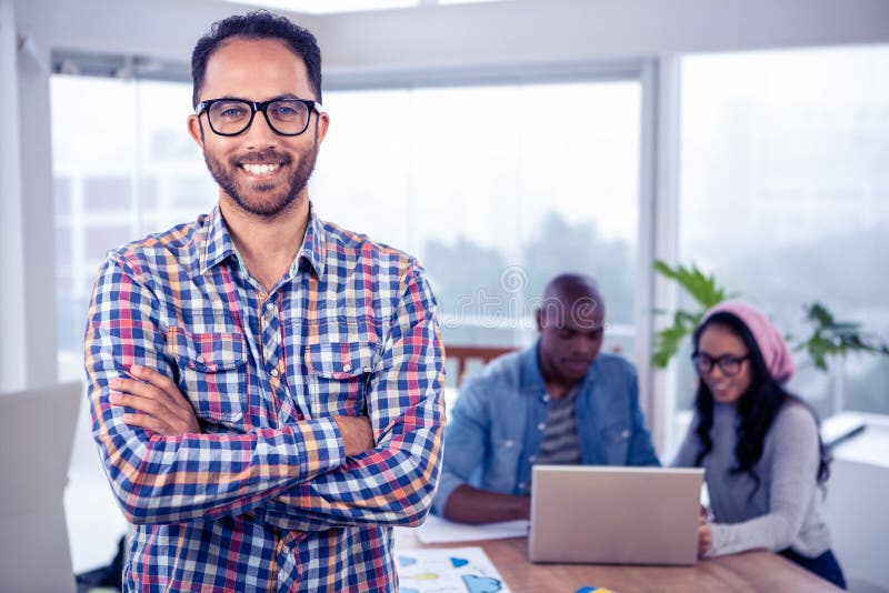 Portretul unui om de afaceri fericit care stă cu brațele încrucișate în birou royalty free stock image