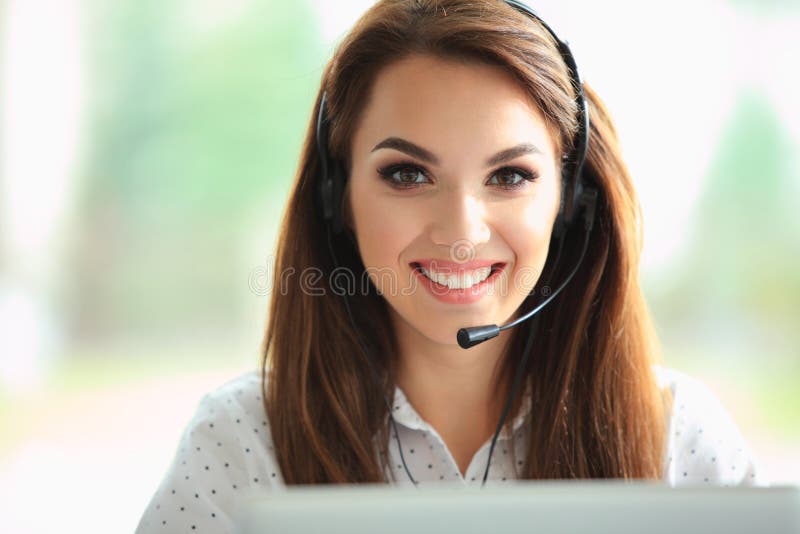 Portretul unui operator de telefon feminin pentru asistență pentru clienți zâmbitor și fericit la locul de muncă. stock photos