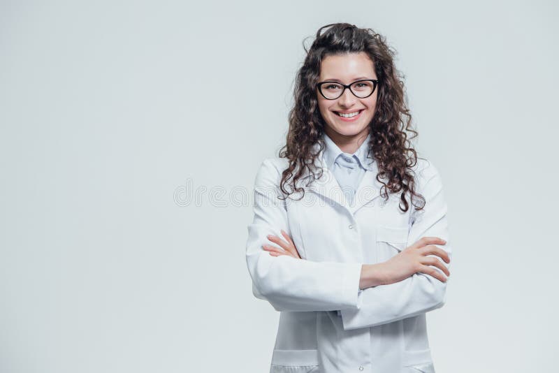 Porträt der lächelnden jungen Ärztin Schöner Brunette im weißen medizinischen Kleid in den Gläsern Holding ohne a lizenzfreie stockbilder Porträt der lächelnden jungen Ärztin Schöner Brunette im weißen medizinischen Kleid in den Gläsern Holding ohne a lizenzfreie stockbilder