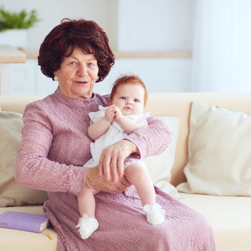 Porträt der schönen reifen Frau 80 Jahre alte Dame mit ihrer neugeborenen Großenkelin zu Hause stockfotografie Porträt der schönen reifen Frau 80 Jahre alte Dame mit ihrer neugeborenen Großenkelin zu Hause stockfotografie