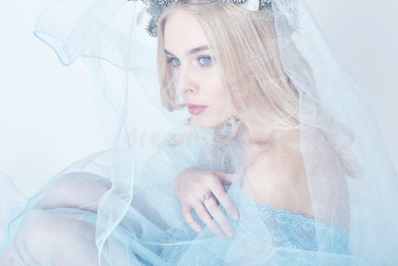 Porträt Blondine mit einem Kranz auf ihrem Haupt- und einem blauen empfindlichen hellen transparenten Kleid Große blaue Augen und lizenzfreie stockfotos Porträt Blondine mit einem Kranz auf ihrem Haupt- und einem blauen empfindlichen hellen transparenten Kleid Große blaue Augen und lizenzfreie stockfotos