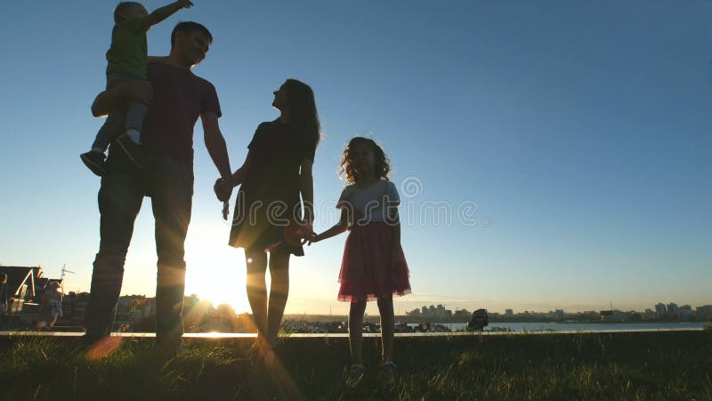 Porträt der glücklichen Familie bei Sonnenuntergang - Vater, Mutter, Tochter und kleiner Sohn - Schattenbild stockbilder Porträt der glücklichen Familie bei Sonnenuntergang - Vater, Mutter, Tochter und kleiner Sohn - Schattenbild stockbilder