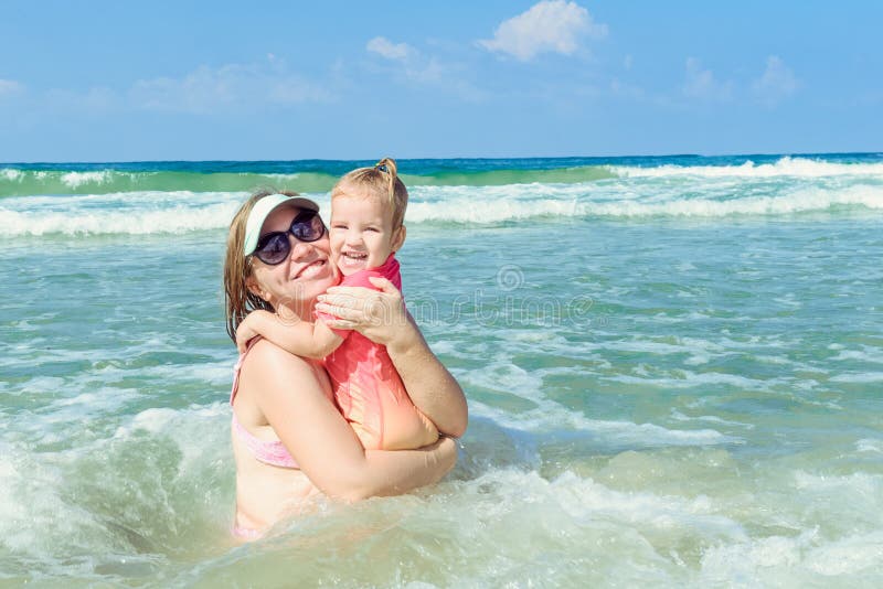 Porträt der glücklichen Familie - Mutter mit Kleinkindtochter in der schützenden Schwimmenklage der Sonne, die Spaßspaß im Seepoo stockfotos Porträt der glücklichen Familie - Mutter mit Kleinkindtochter in der schützenden Schwimmenklage der Sonne, die Spaßspaß im Seepoo stockfotos