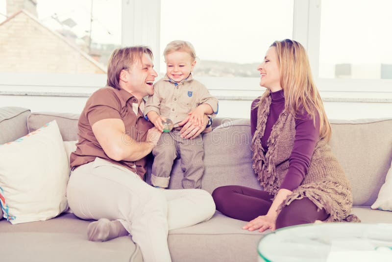 Porträt der glücklichen Familie sitzend auf dem Sofa und dem Spielen stockbild Porträt der glücklichen Familie sitzend auf dem Sofa und dem Spielen stockbild