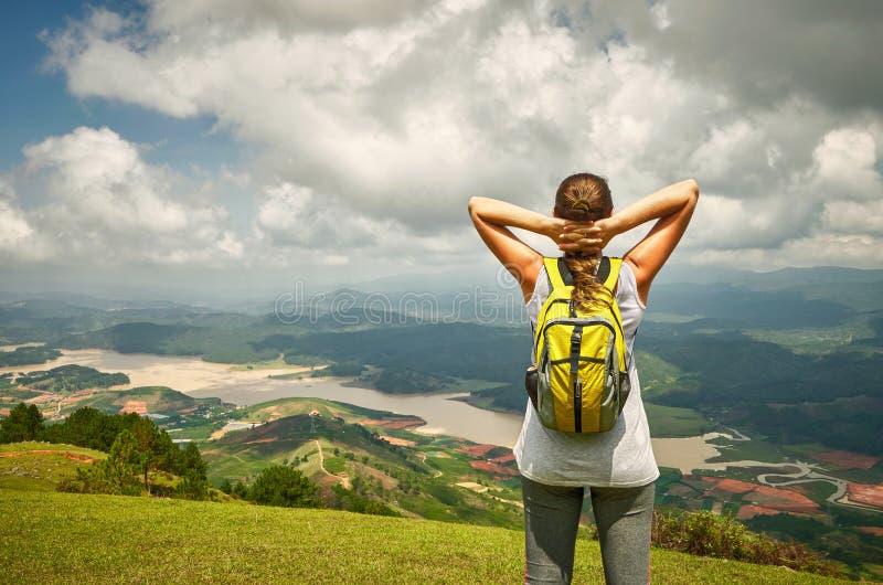 Porträt der glücklichen Reisendfrau mit dem Rucksack, der auf Oberseite O steht lizenzfreies stockbild Porträt der glücklichen Reisendfrau mit dem Rucksack, der auf Oberseite O steht lizenzfreies stockbild